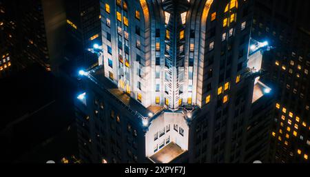 Vue aérienne de paysages nocturnes au-dessus du Lower East Side de Manhattan. Gros plan vue d'arc de la flèche du bâtiment Chrysler avec des lumières qui brillent des fenêtres sur le toit Banque D'Images