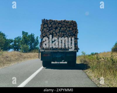 Camion chargé avec bois de chauffage pour la saison à venir : sur la route à travers un paysage rural. Quelque part en Macédoine 2024. Banque D'Images