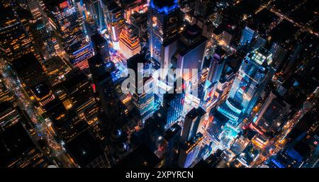 Visite nocturne en hélicoptère de l'architecture de la ville de New York. Times Square éclatant avec des groupes de touristes appréciant la vie nocturne de Manhattan et admirant le Landmark avec divers panneaux publicitaires Banque D'Images