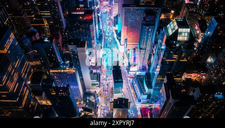 Visite nocturne en hélicoptère de l'architecture de la ville de New York. Times Square illuminé avec des groupes de touristes appréciant la vie nocturne de Manhattan et admirant le monument avec divers panneaux publicitaires Banque D'Images