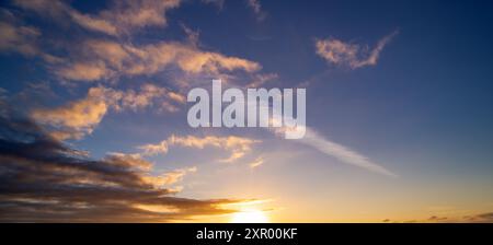 Les nuages du coucher du soleil se rassemblent. Ciel panoramique de lever ou de coucher de soleil avec des nuages. Coucher de soleil ciel sur crépuscule dans la soirée avec coucher de soleil. Nuage nature ciel Banque D'Images