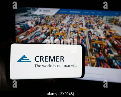 Personne tenant un smartphone avec le logo de la société allemande Peter Cremer Holding GmbH Co. KG devant le site Web. Concentrez-vous sur l'affichage du téléphone. Banque D'Images