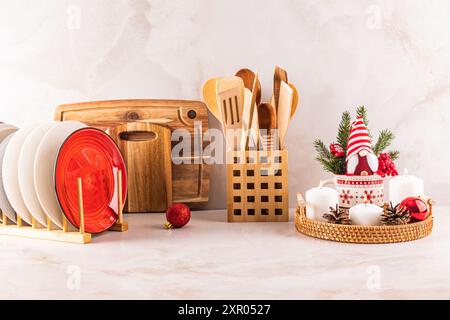 Comptoir de cuisine en marbre décoré dans un style minimaliste pour le nouvel an et Noël. Un séchoir avec des assiettes, un ensemble de bougies, un gnome du nouvel an. Banque D'Images