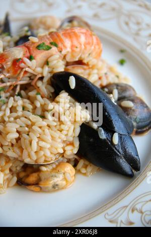 Risotto de fruits de mer au restaurant sicilien de bord de mer à Cefalù, Sicile, Italie. Banque D'Images