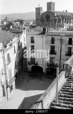 Wohnhäuser in der Innestadt von Castelló d'Empúries, im Hintergrund erhebt sich das Wahrzechen der Stadt, die Basilika Sankt Marien, Costa Brava 1957. Immeubles résidentiels dans le centre-ville de Empúries d'Castelló, en arrière-plan s'élève le monument de la ville, la Basilique de la Marie, Costa Brava 1957. Banque D'Images