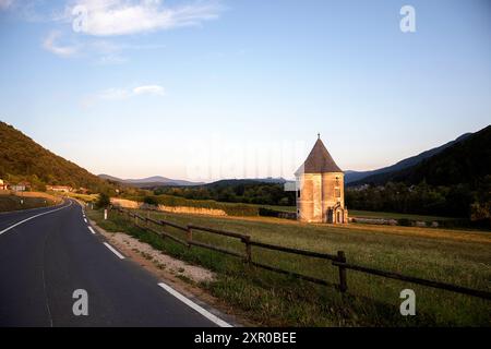 Spectaculaire Tour du Diable et une route locale passant au revoir, entouré de belles prairies, champs près de la rivière Krka dans la région de Dolenjska, Slovénie Banque D'Images