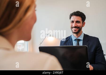 Un responsable des ressources humaines mène un entretien d'embauche avec un nouvel employé. Un vendeur, un directeur financier ou un courtier en valeurs mobilières discutant et rencontrant un client dans son bureau. Photo de haute qualité Banque D'Images