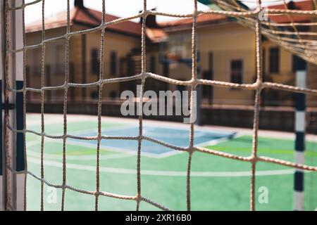 Gros plan d'un filet de but de football avec une vue floue d'un terrain de sport vide Banque D'Images