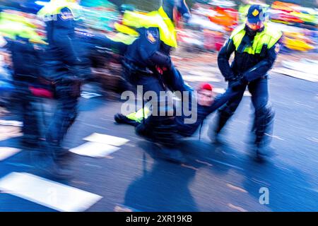 Bloc de la rébellion XR de l'autoroute A12 et Utrechtsebaan les activistes de la rébellion XR bloquent l'autoroute A12 menant à la ville le 11 mars 2023 pour exiger l'interdiction du financement des coopérations sur les combustibles fossiles par le gouvernement national. Puisqu’il s’agissait de la troisième manifestation sur ce spot, Riot & Military police a violemment mis fin au rassemblement de plus de 3,000 militants et partisans. La Haye, pays-Bas. Den Haag, s-Gravenhage, The Hag A12 / Utrechtsebaan Zuid-Holland Nederland Copyright : xGuidoxKoppesx Banque D'Images