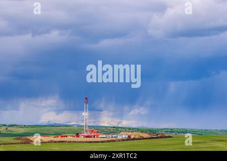 Un appareil de forage sur un site de puits dans les contreforts des montagnes Rocheuses en Alberta Banque D'Images