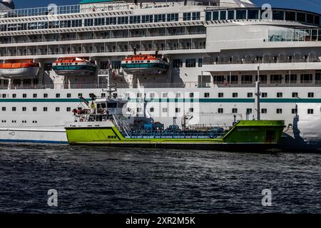 Navire de croisière Amera au quai Skoltegrunnskaien dans le port de Bergen, Norvège. Réception de bunkers du pétrolier Haltbakk Viking Banque D'Images