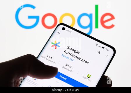 Gros plan de l'écran d'un smartphone affichant l'application Google Authenticator avec le logo Google en arrière-plan, illustrant la connexion entre Google aut Banque D'Images