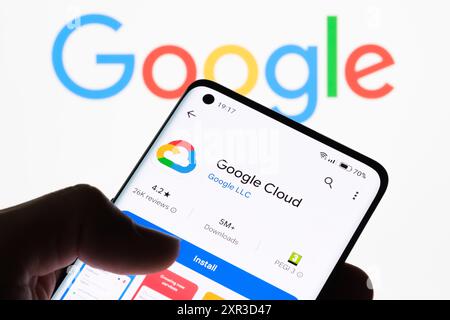 Gros plan de l'écran d'un smartphone affichant l'application Google Cloud avec le logo Google en arrière-plan, montrant le lien entre Google Cloud et Google, STAF Banque D'Images