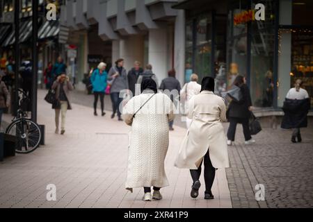 Deux femmes en foulards islamiques sont vues marcher dans le centre-ville animé d'Aix-la-Chapelle, en Allemagne. L'image capture un mélange de a islamique traditionnel Banque D'Images