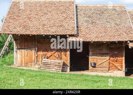 Cette image représente des écuries dans la campagne serbe, caractérisées par des structures traditionnelles en bois. La scène reflète le mode de vie rural et Agri Banque D'Images