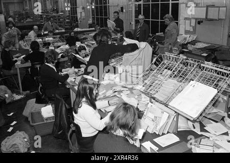 Occupé dans le service de tri. Bureau de poste de V.H. à Baljuwslaan, PTT, bureau de poste, poste de ville, Haarlem, Baljuwslaan, pays-Bas, 15-12-1975, Whizgle Dutch News : des images historiques sur mesure pour l'avenir. Explorez le passé néerlandais avec des perspectives modernes grâce à des images d'agences néerlandaises. Concilier les événements d'hier avec les perspectives de demain. Embarquez pour un voyage intemporel avec des histoires qui façonnent notre avenir. Banque D'Images