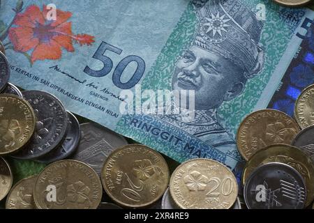 Terengganu, Malaisie - 24 août 2024 : gros plan de pièces de monnaie malaisiennes dispersées et de 50 ringgits d'argent malaisien Banque D'Images