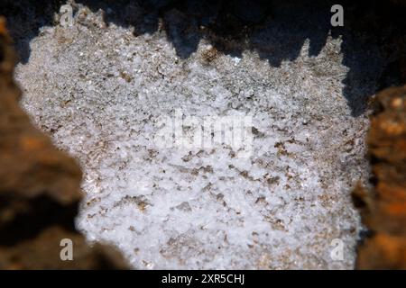 Roche recouverte d'une couche de sel frais, soulignant la texture et le contraste des surfaces Banque D'Images