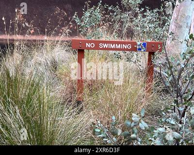 Alice Springs, Australie. 05 août 2024. Un panneau à Uluru dans le territoire du Nord interdit de nager dans un point d'eau. Crédit : Carola Frentzen/dpa/Alamy Live News Banque D'Images