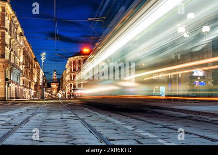 Tramway en mouvement flou passant la nuit dans les rues de Milan en Italie Banque D'Images