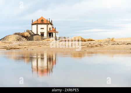 Chapelle au milieu de la plage à côté de l'eau de Senhor da Pedra à Miramar, Portugal Banque D'Images