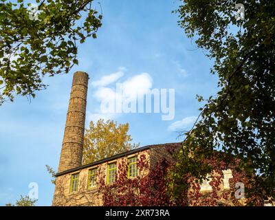 L'extérieur du moulin Hebden Bridge couvert de Virginia Creeper à l'automne. L'ancien moulin est maintenant un café et un point de vente au détail. Pont Hebdon. West Yorkshire Banque D'Images