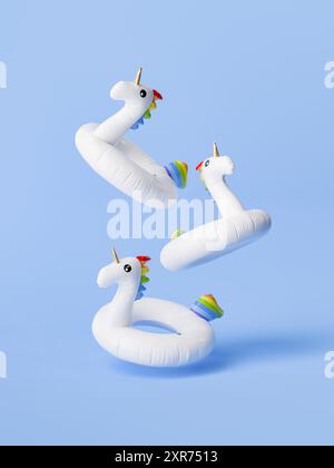 rendu 3d de trois anneaux de piscine licorne blanche avec des détails colorés flottant en milieu d'air sur un fond bleu clair. Concept d'été fantaisiste. Banque D'Images