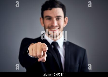 Portrait d'homme d'affaires, choisissez et pointez vers vous pour l'occasion de décision de recrutement ou d'invitation. Fond gris, geste du doigt ou de la main dans Banque D'Images