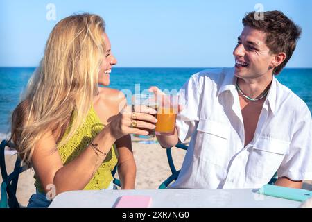 Heureux jeune couple en vacances, boire au restaurant Banque D'Images
