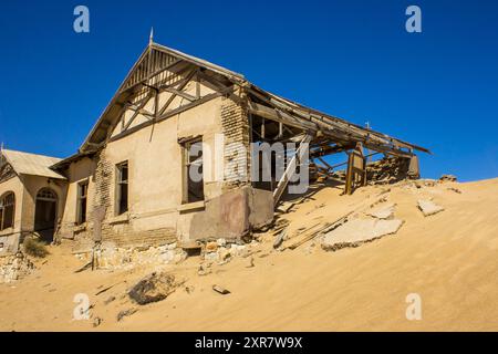 L'ancienne maison des maîtres d'école, enterrée par une dune de sable, dans la ville abandonnée des mines de diamants de Kolmanskuppe. Banque D'Images