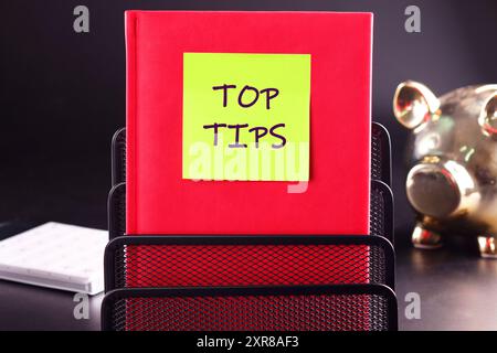 Texte TOP TIPS concept d'entreprise. MEILLEURS CONSEILS sur l'autocollant sur le livre rouge d'affaires Banque D'Images