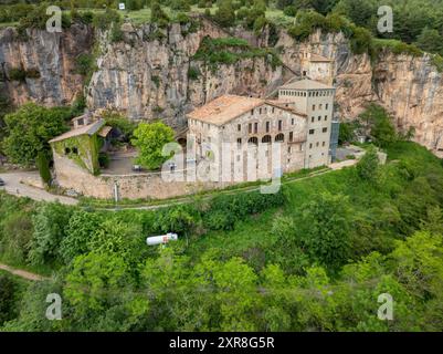 Vue aérienne du sanctuaire de Montgrony construit au pied d'une falaise dans la chaîne montagneuse de Montgrony (Ripollès, Gérone, Catalogne, Espagne, Pyrénées) Banque D'Images