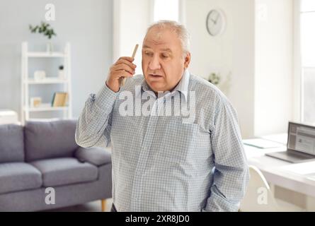 Vieil homme âgé retraité, personne âgée tenant , en utilisant le téléphone portable pour communiquer Banque D'Images