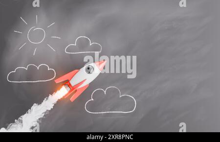 Fusée stylisée se lançant sur un tableau noir avec des nuages tracés à la craie et du soleil. Concept d'éducation et de créativité. rendu 3d. Banque D'Images