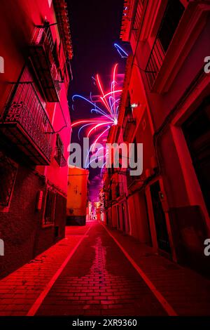 Feux d'artifice reflétés dans une flaque d'eau des rues de Villajoyosa. Banque D'Images