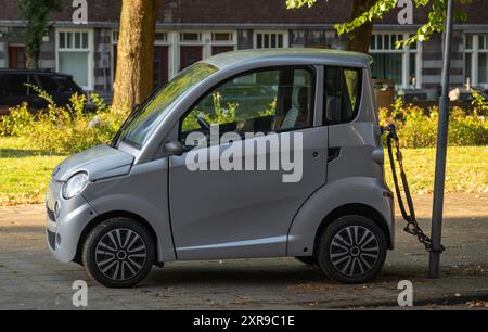 Amsterdam, pays-Bas, 05.08.2024, micro voiture néerlandaise à deux places Canta Premium garée dans la rue et verrouillée à un poteau métallique Banque D'Images