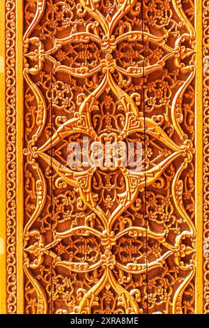Fragment d'une ancienne porte en bois dans une madrasa. Khiva, Ouzbékistan - 20 juillet 2024. Banque D'Images
