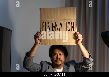 Démission. homme d'affaires tenant des boîtes pour les effets personnels et les lettres de démission. Quittant un emploi, le grand démissionne. La grande démission. Banque D'Images