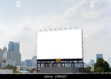 L'image montre un grand panneau d'affichage vierge au milieu d'un paysage urbain. Les grands bâtiments et la circulation peuvent être vus en arrière-plan. Publicité et po Banque D'Images