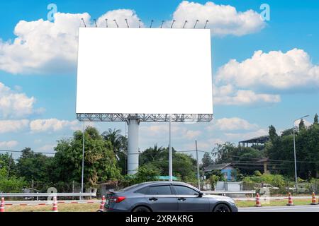 En été, ciel bleu, autoroute et panneau d'affichage. Panneau publicitaire exceptionnel sur le côté de la voie publique. Panneau d'affichage vierge sur ciel bleu prêt pour ne Banque D'Images