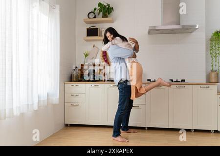 Bel homme blanc et jeune femme afro-américaine attirante cuisine et s'amuser ensemble tout en cuisinant sur la cuisine, romantique interracial c Banque D'Images