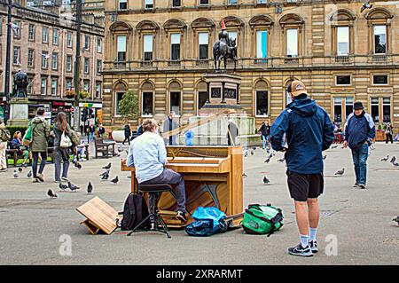 Glasgow, Écosse, Royaume-Uni. 9 août 2024. Les gars traînant du piano à travers l'europe jouent dans le centre de la ville sur george Square avec des planches montrant son voyage et etre. En TOURNÉE 24 : #busking à #nessie en direction du loch ness m.youtube.com/@2thestars prochain arrêt du festival d'édimbourg. . Crédit Gerard Ferry /Alamy Live News Banque D'Images