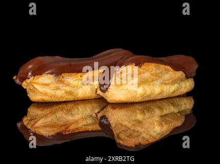 Deux eclairs à la crème, macro, isolés sur un fond noir. Banque D'Images