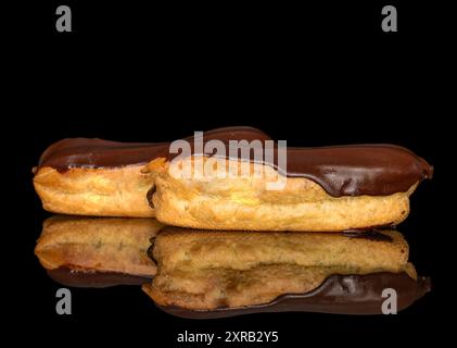 Deux eclairs à la crème, macro, isolés sur un fond noir. Banque D'Images