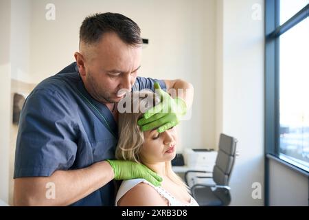 Ostéopathe effectuant une manipulation du rachis cervical, séance de thérapie craniosacrale Banque D'Images