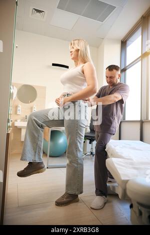 Un professionnel de santé effectuant une palpation lombaire chez une femme adulte Banque D'Images