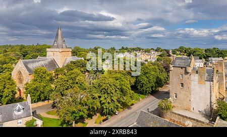 Dornoch Sutherland Écosse le bâtiment de la cathédrale entouré par les arbres de la rue Castle et le Castle Hotel sous le soleil d'été Banque D'Images