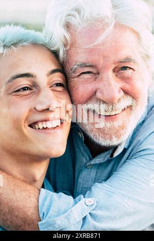 Père et fils ou grand-père et petit-fils ensemble hug et profiter avec le sourire - gai différents âges caucasiens en plein air - concept d'âges et de générations mixtes hommes Banque D'Images