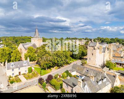 Dornoch Sutherland Écosse le bâtiment de la cathédrale entouré par les arbres Castle Street et le grand Castle Hotel sous le soleil d'été Banque D'Images