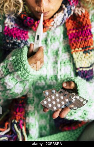 Femme malade à la maison vérifier la température de la fièvre et prendre des médicaments de pilules pour lutter contre la grippe et la toux - coronavirus covid-19 évasion des gens avec la science et les soins Banque D'Images